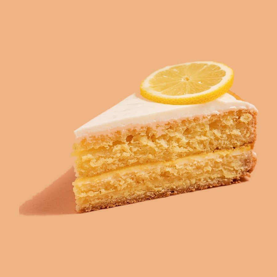Stück Zitronenkuchen mit Guss und Zitronenscheibe